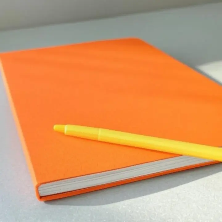 Közeli felvétel minőségi tollról és jegyzetfüzetről