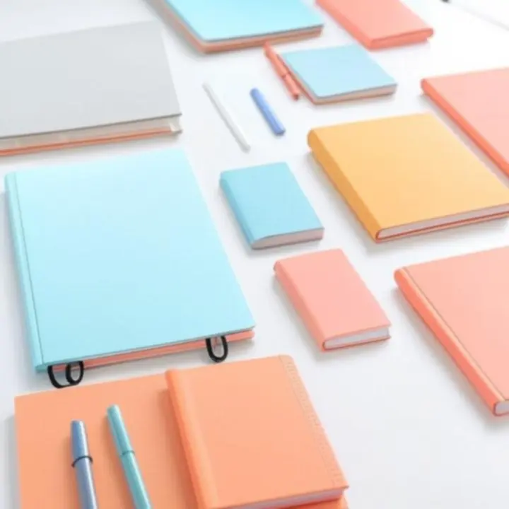 Színes, lapos elrendezésű papír-írószer kollekció asztalon